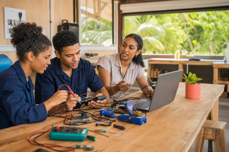 Beroepsstudenten bouwen samen een digitaal prototype met elektronica en een laptop.